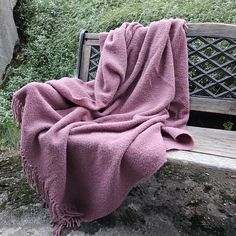 a blanket is sitting on a wooden bench