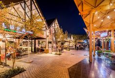 an empty street with tables and chairs at night