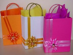 three colorful gift bags with bows on them