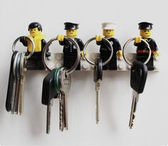 several lego people holding keys in each other's hands and hanging on the wall