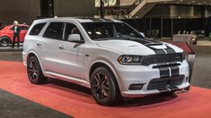 a white dodge duran is on display at an auto show