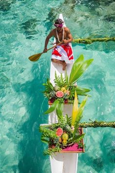 a man rowing a boat with plants on it