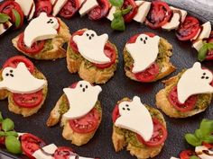 small appetizers with tomatoes, cheese and ghost faces on them are arranged in a circle