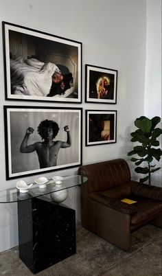 a living room with pictures on the wall and a couch in front of it next to a coffee table