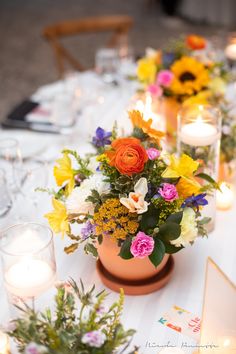 a table with flowers and candles on it