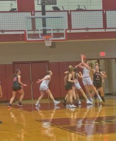 a group of girls playing basketball in a gym