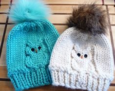 two knitted hats sitting on top of a wooden table