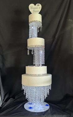 a three tiered wedding cake is adorned with crystal beading and heart shaped decorations