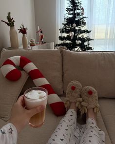 a person sitting on a couch with their feet propped up holding a glass of beer