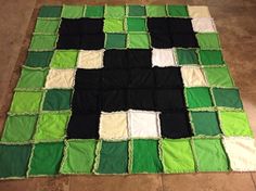 a green, black and white rug on the floor with an odd shape made out of squares