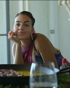 a woman sitting at a table with food in front of her and looking off to the side