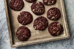 chocolate cookies with nuts on a baking sheet