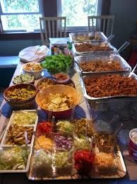 a long table filled with lots of food on top of plates and pans next to each other