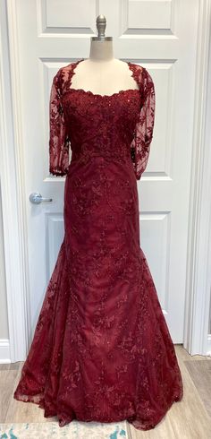 a red dress on display in front of a white door with a blue floral design