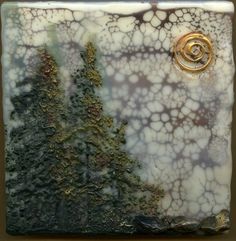 a decorative tile with trees on it and a gold ring in the center, sitting on a table