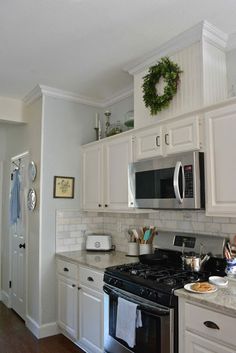 a kitchen with white cabinets and black appliances