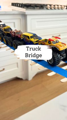 toy trucks are lined up on top of each other in the kitchen, along with blue tape