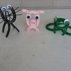 three plastic animal heads are sitting on the floor next to each other, one with eyes and two without