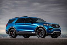 a blue ford explorer is parked on the road