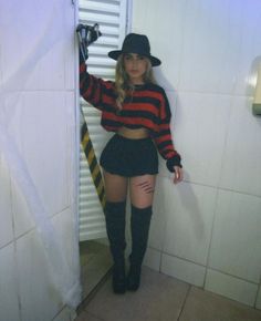 a woman in short shorts and knee high boots posing for the camera with her hat on