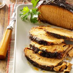 sliced pork on a white plate with parsley