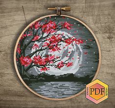 the cross stitch pattern shows a beautiful red tree with flowers on it, in front of a wooden background