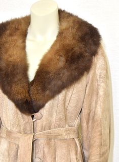 A beautiful vintage Rajac Leather women's coat sewn from a mottled tan suede in stripes or thin gores with a luxurious fox fur collar. ~ plunging V neckline which converts to a close-to-the-neck collar ~ satin ties and suede loop inner side closure ~ belt with belt loops ~ suede loops & suede-covered button closure  ~ insulated satin lining ~ front welt pockets  ~ multi-gored design ~ raglan sleeves [label]  Rajac Leathers [manufacturing]  made in Canada [fiber content]   suede, fox fur,  lining Suede Coat, Vintage Coat, Tan Suede, Fur Collar, Fur Collars, Vintage Wool, Fox Fur, Neck Collar, Women's Coat