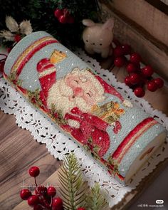 a christmas cake decorated with santa clause on top of a doily next to berries