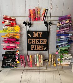 a sign that says my cheer pins on it next to some candy bars and candies