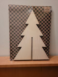 a cardboard christmas tree sitting on top of a wooden table