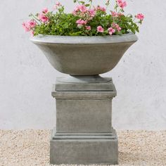 a cement planter with pink flowers in it