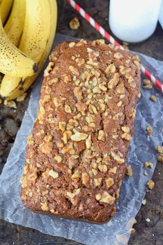 a loaf of bread sitting on top of a piece of wax paper next to some bananas