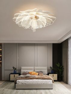 a bed room with a neatly made bed and a ceiling light