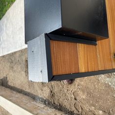 a close up of a speaker on the side of a building with grass in the background