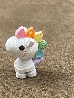 a small toy dog with colorful hair on it's head sitting on the ground