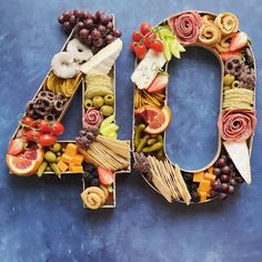 the number 40 made out of fruits and vegetables is displayed on a blue surface with other food items