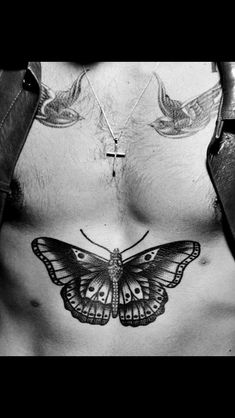 a man's chest with a butterfly tattoo on his chest and two birds flying above him