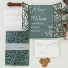 the wedding stationery is laid out on top of each other, including two coins