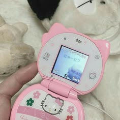 a person holding a pink hello kitty mp3 player