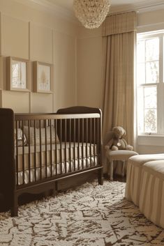 a baby's room with a crib in the corner and pictures on the wall