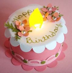 a birthday cake with flowers and a lit candle