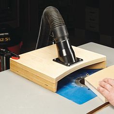 a person is using a machine to cut wood with a piece of plywood board