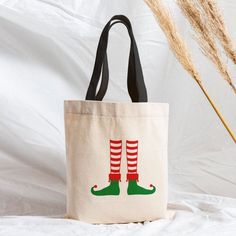 a tote bag sitting on top of a bed next to a tall grass plant