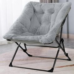 a grey chair with a black frame and legs on top of a carpeted floor