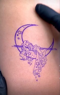 a tattoo on the back of a woman's stomach with a crescent and stars