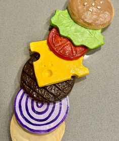 an assortment of cookies made to look like hamburgers and cheese on top of each other