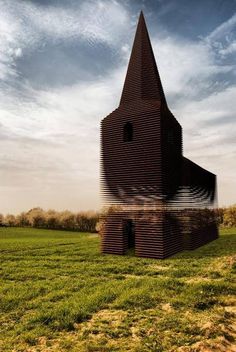 an unusual building in the middle of a field