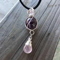 Handmade Wire Wrapped Rose Quartz Amethyst Crystal Ball Briolette Pendant Necklace ( Or Car Mirror Charm! ) Features: - Wrapped In Pure Copper Wire With A Non Tarnish Silver Finish. - Hangs On An Adjustable Black Faux Suede Necklace Rope With 28” At Longest Length. - 16mm Chevron Amethyst Sphere With A Rose Quartz Briolette Dangle Charm. - Versatile; Elegant, Looks Beautiful Dressed Up Or For Everyday Wear. Amethyst Is Known For Its Calming, Protective, & Spiritual Qualities. It Can Help With Em Silver Rose Quartz Jewelry With Birthstone, Wire Wrapped Crystal Necklace In Sterling Silver, Silver Teardrop Pendant Necklace Hand Wrapped, Pink Amethyst Wire Wrapped Jewelry, Sterling Silver Hand Wrapped Necklace, Hand Wrapped Sterling Silver Necklace, Hand Wrapped Sterling Silver Round Necklace, Bohemian Silver Rose Quartz Necklaces, Purple Rose Quartz Jewelry For Healing