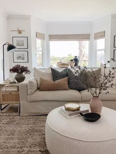 a living room filled with lots of furniture next to a white couch and coffee table