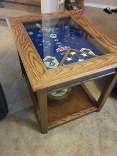 a wooden table with a glass top sitting on the floor